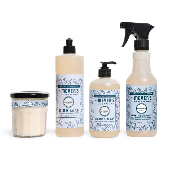 The Mrs. Meyer’s Festive Freshness Set features four honeysuckle-scented products—soy candle, dish soap, hand soap with pump, and multi-surface spray—each with blue and white labels for a clean, fresh look.