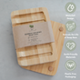 The Me Mother Earth Bamboo Draining Soap Dish, shown on a light surface with its label, features a waterfall design to extend soap life and is made from earth-friendly materials with plastic-free packaging.