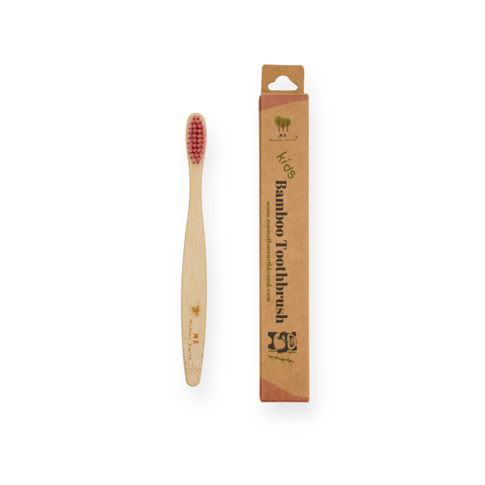 The Me Mother Earth Kids Colorful Bamboo Toothbrush with Castor Oil Bristles lies next to its brown cardboard box labeled “Bamboo Toothbrush,” both showcasing eco-friendly, sustainable oral care on a white background.