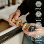 A person holds the Me Mother Earth Scrub Brush for Pots and Pans over a sink. Icons highlight features: ideal for pots and pans, made with earth-friendly materials, replaceable plant-based bristles, and plastic-free packaging.