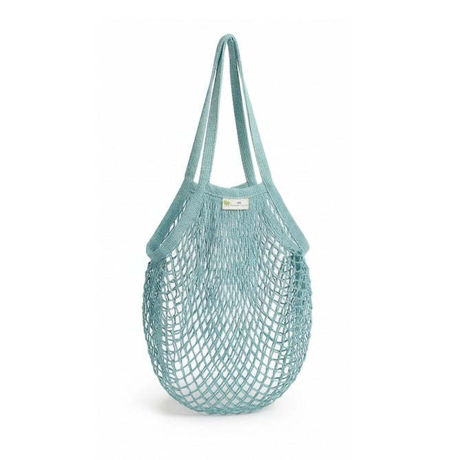 The "One Tripper" Expandable Mesh Market Bag by Me Mother Earth is a light blue, reusable organic cotton bag with two handles, ideal for carrying groceries or produce. Shown empty against a white background.
