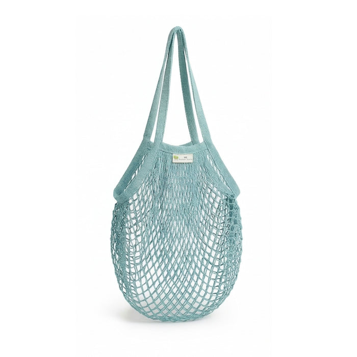 The "One Tripper" Expandable Mesh Market Bag by Me Mother Earth is a light blue, reusable organic cotton bag with two handles, ideal for carrying groceries or produce. Shown empty against a white background.