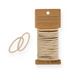 A pack of 20 beige Me Mother Earth Hair Ties made from cotton and natural rubber, featuring two ties displayed separately beside the pack on a brown cardboard backing with product details.