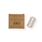A Me Mother Earth Safety Razor Refill Pack in a brown cardboard box with instructions and barcode is shown next to a single stainless steel replacement blade on a white background.