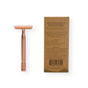 The Me Mother Earth Reusable Double Edge Safety Razor in rose gold stands upright beside a brown box featuring product details and instructions in black text, plus a barcode—ideal for zero waste shaving routines.