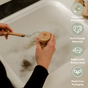 Someone washes dishes over a sink using the Me Mother Earth Sisal Kitchen Brush. Four icons on the right show its benefits: ideal for dishwashing, made from earth-friendly materials, with a replaceable bristle head, and plastic-free packaging.