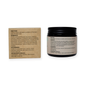 Two containers are shown: a square box and a dark amber glass jar, both labeled with directions, ingredients, and storage details for Me Mother Earth Fluoride-Free Toothpaste Tablets—plastic-free tablets for personal care.