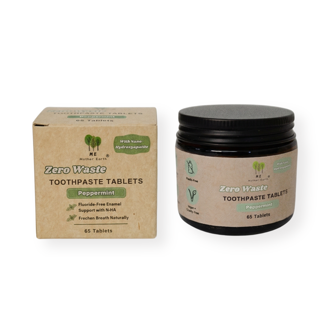 A box and an amber glass jar of Me Mother Earth’s fluoride-free Toothpaste Tablets in peppermint are shown. Packaging displays eco-friendly icons, states 65 enamel-supporting tablets, and highlights their travel-friendly design.