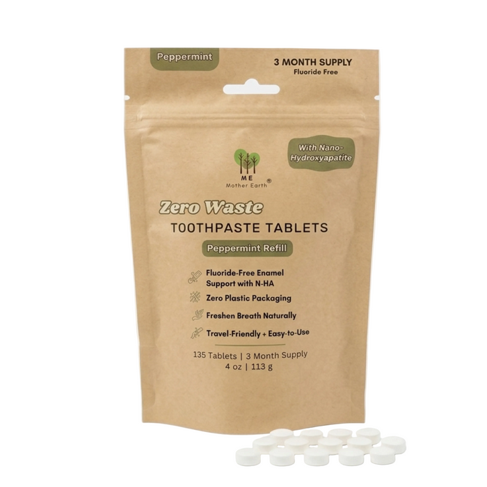 A brown refill pouch labeled "Me Mother Earth Toothpaste Tablets 3 Month Refill - Fluoride-Free, Peppermint" features plant-based and enamel-supporting details. Small white toothpaste tablets are displayed in front of the pouch.