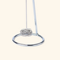 A close-up of the Morning Made Modern Whisk, a metal coffee frother with a circular coiled whisk and shiny stand, set against a light beige background.