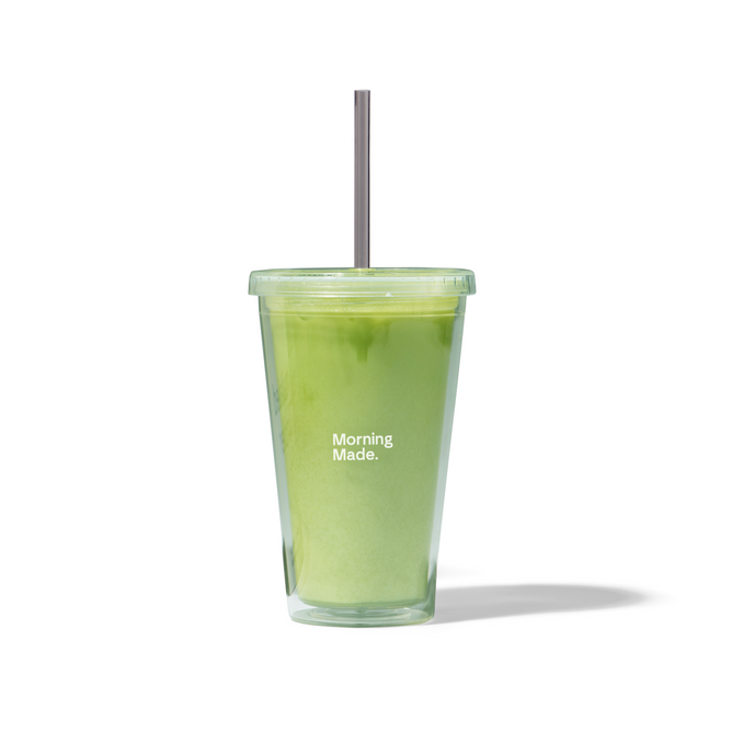The Morning Made Insulated Tumbler, complete with a metal straw, holds a creamy green matcha drink as a coffee alternative. “Morning Made.” is printed on the front, and the reusable tumbler casts a soft shadow on white.