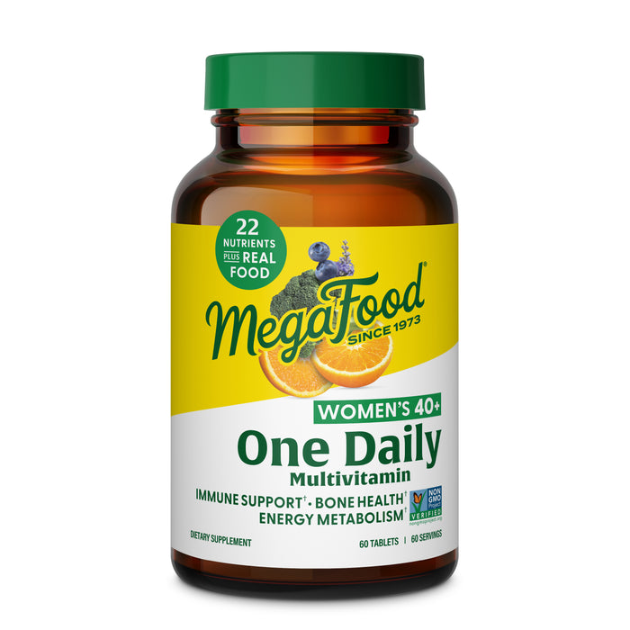 A bottle of MegaFood Women’s 40+ One Daily multivitamin in a brown glass container with a yellow-green label featuring orange slices and kale, supports immune health, energy, bone strength, and hair, skin & nails.