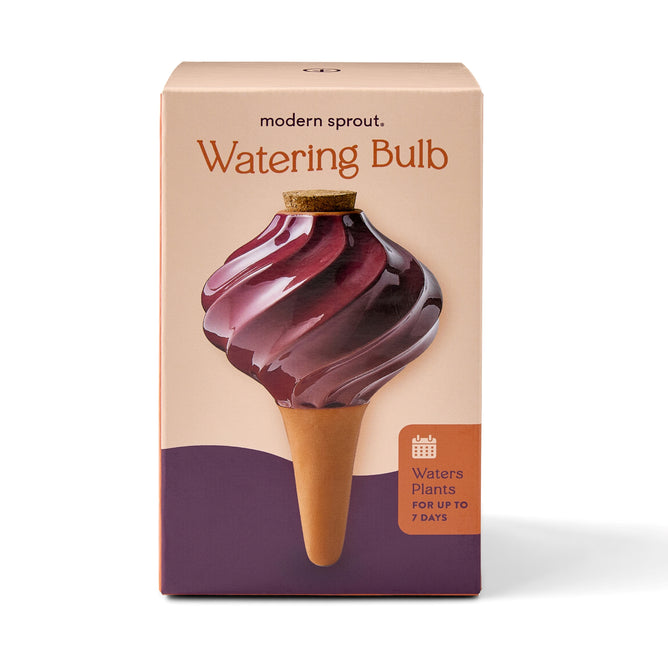 Modern Sprout’s Watering Bulb features a glass, swirl design with a cork top and glazed terracotta spike, watering plants for up to 7 days.