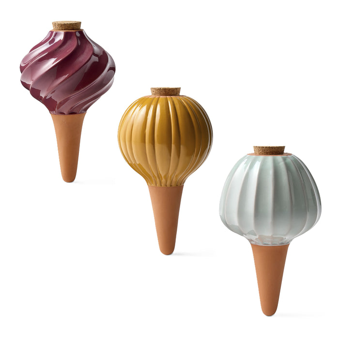 The Modern Sprout Watering Bulbs Variety Pack includes three ceramic self-watering stakes with textured, bulb-shaped tops in burgundy, mustard yellow, and light blue for easy plant care.
