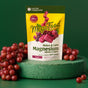 A yellow and white pouch of MegaFood Relax Plus Calm Magnesium Soft Chews stands on a green surface, surrounded by clusters of red grapes, with a green background.