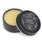 An open Chagrin Valley Soap & Salve Honey Butter Lip Balm tin with a floral lid rests on a white background. The organic, light yellow balm inside soothes dry, chapped lips with real honey.