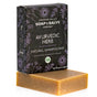 A brown rectangular Natural Shampoo Bar made with organic coconut milk rests in front of a Chagrin Valley Soap & Salve box labeled “Ayurvedic Herb Natural Shampoo Bar” with floral designs and product details.