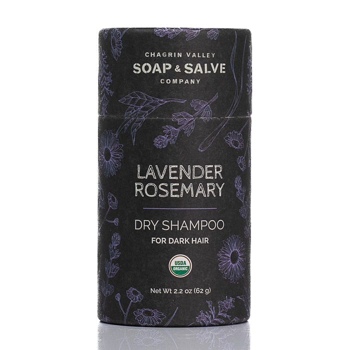 A cylindrical container of Chagrin Valley Soap & Salve Dry Hair Shampoo: Dark Hair features a floral design on a dark background and displays the USDA Organic label on the front.
