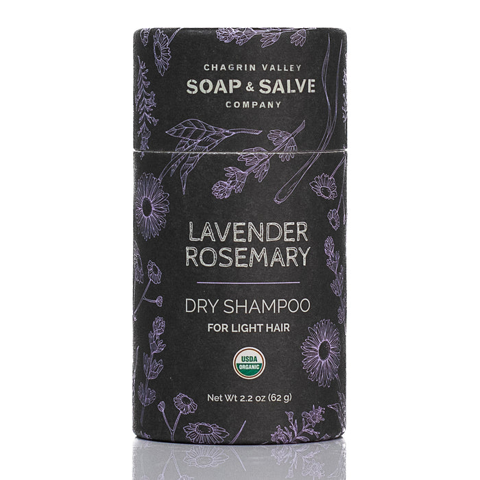 A cylindrical container of Chagrin Valley Soap & Salve Dry Hair Shampoo: Light Hair, featuring lavender and botanical art on a black background. The USDA Organic label is visible. Adds volume and texture while absorbing oil.