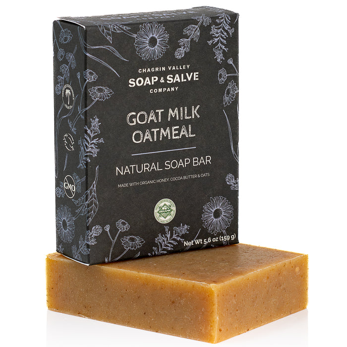 A brown rectangular Natural Soap Bar from Chagrin Valley Soap & Salve, unscented and moisturizing for sensitive skin, is placed in front of its dark floral-patterned box.
