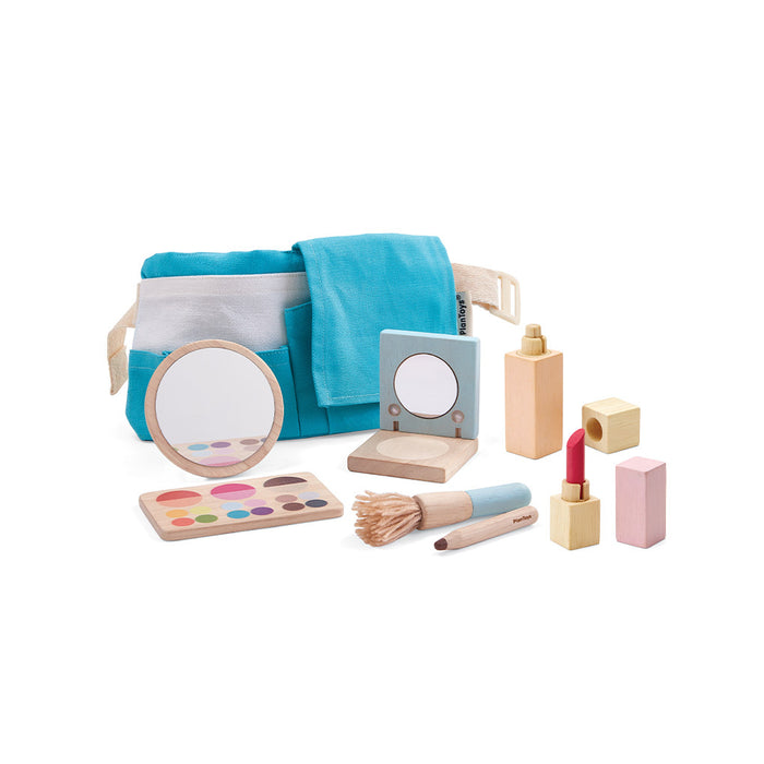 The PlanToys Pretend Play Wooden Makeup Set for Kids includes a mirror, palette, brush, lipstick, perfume bottles, and a blue fabric bag with pockets—all arranged on a white background.