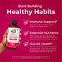 A hand holds a bottle of MaryRuth's Morning Multivitamin Liquid against a pink background. Text highlights Immune Support, Essential Nutrients, and Overall Health benefits, each marked with a checkmark icon.