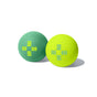 Pedestrian Project Foot Massage Balls—set of two, one green and one yellow, each featuring cross-shaped blue and yellow lines. Designed for foot relaxation and stress relief; shown on a white background with soft shadow.