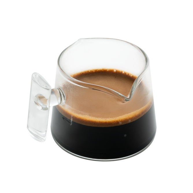 A Pure Over Espresso Measuring Glass / Coffee Dosing Glass, filled with dark espresso and topped with rich crema, sits on a white background.