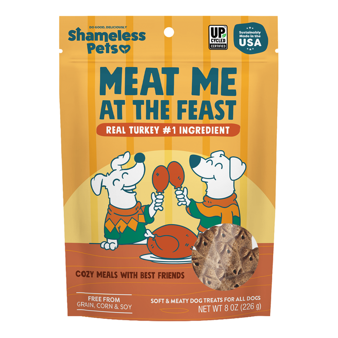 A bag of Shameless Pets Dog Treats – Meat Me At The Feast, featuring cartoon dogs holding drumsticks, showcases real turkey as the main ingredient and emphasizes that the treats are free from grain, corn, and soy.