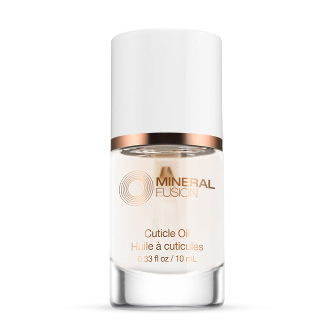 A clear glass bottle of Mineral Fusion Nail Treatment Cuticle Oil for natural nail care, with a white cap and rose gold accents. The bilingual label displays the brand and product name, containing 0.33 fl oz (10 mL) of oil.
