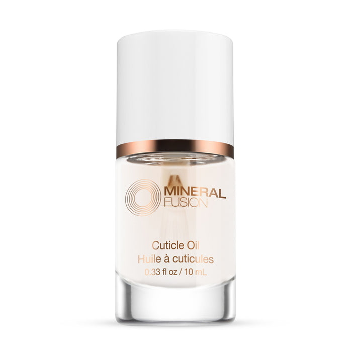 A clear glass bottle of Mineral Fusion Nail Treatment Cuticle Oil for natural nail care, with a white cap and rose gold accents. The bilingual label displays the brand and product name, containing 0.33 fl oz (10 mL) of oil.