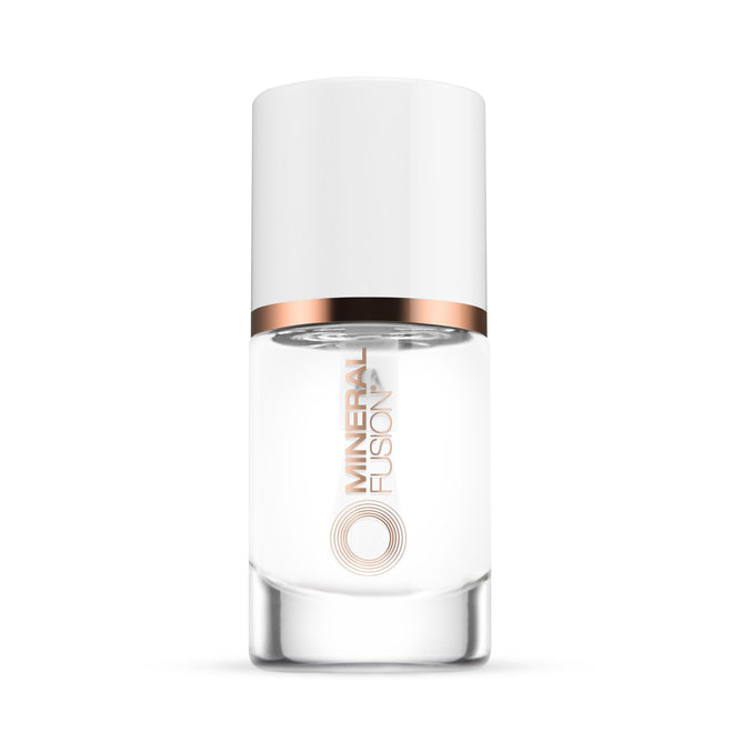 A clear glass bottle of Mineral Fusion Nail Treatment Top Coat with a white cap and rose gold band delivers salon-quality results. The label reads Mineral Fusion in metallic letters. Perfect for pairing with Base Coat. Set against a white background.
