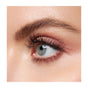 Close-up of a blue eye with long, voluminous lashes from Mineral Fusions So Classy Volume Mascara, paired with shimmery pink eyeshadow, a well-groomed brow, and smooth, fair skin.
