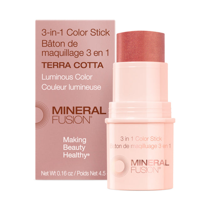 A Mineral Fusion 3-in-1 Color Stick stands next to its box, twisted up to show a shimmering peachy-brown tint. Text highlights its luminous color and healthy beauty benefits.