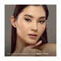 A woman with straight dark hair and flawless makeup poses with her hand near her chin. Her defined, natural-looking brows showcase: “Amy is wearing Mineral Fusion Retractable Brow Pencil in Medium Brown.”.