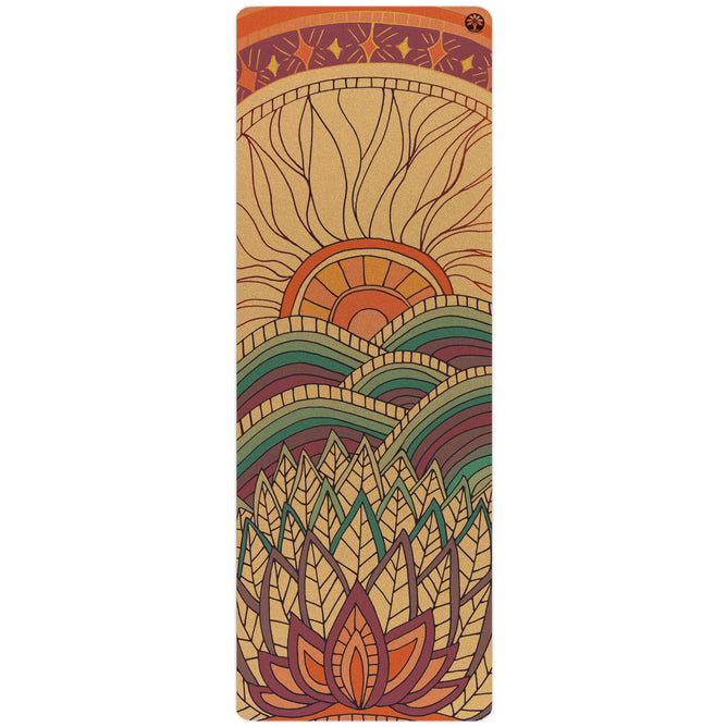 The Mountain Magic Aura Cork Yoga Mat by Yoloha Yoga is a sustainable yoga mat featuring a colorful design with a stylized sun rising over wavy hills and layered lotus petals in orange, green, and purple tones.