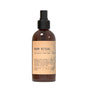 The Muse Apothecary Room Spray - Olive Collection features Tuscan thyme and olive laurel notes in a brown glass bottle with a black nozzle and minimalist beige label adorned with botanical illustrations.