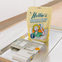 A yellow Nellie’s Dishwasher Powder Pouch sits on an open dishwasher door by the detergent tray. The package, with a retro-style woman, notes it’s phosphate-free, septic safe, and provides 50 scoops per bag.