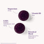 Two round, dark purple Natrol Sleep & Restore Gummies Non-Melatonin are shown. Text highlights each gummy has Magnesium 100mg, GABA 100mg, Vitamin B6 10mg, and a botanical blend (tart cherry, lemon balm, chamomile) 25mg.