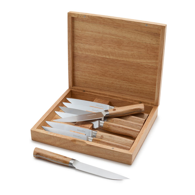 The GreenPan Elite Light Pakka Wood Steak Knife Boxed Set features six ergonomic steak knives with precision-cut blades and wooden handles, displayed in an open wooden box with one knife placed in front.