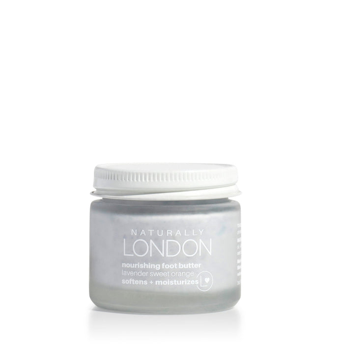 A small frosted glass jar with a white lid, labeled Naturally London Nourishing Foot Butter, sits centered on a white background. This moisturizing foot cream is ideal for softening and repairing dry feet.