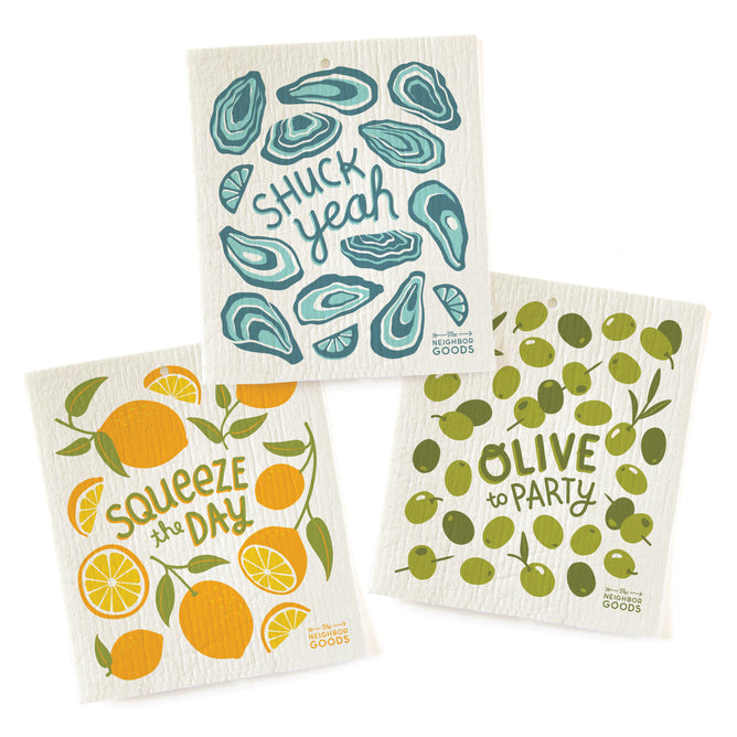 The Neighborgoods Sponge Cloth set includes three eco-friendly cloths: oysters with “Shuck Yeah”, lemons with “Squeeze the Day”, and olives with “Olive to Party”—each featuring playful, colorful designs for your kitchen.