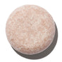 The Fixer Shampoo by NOTICE Hair Co is a round, pale pink bar with a speckled texture—ideal for plastic-free hair care and repairing damaged hair.
