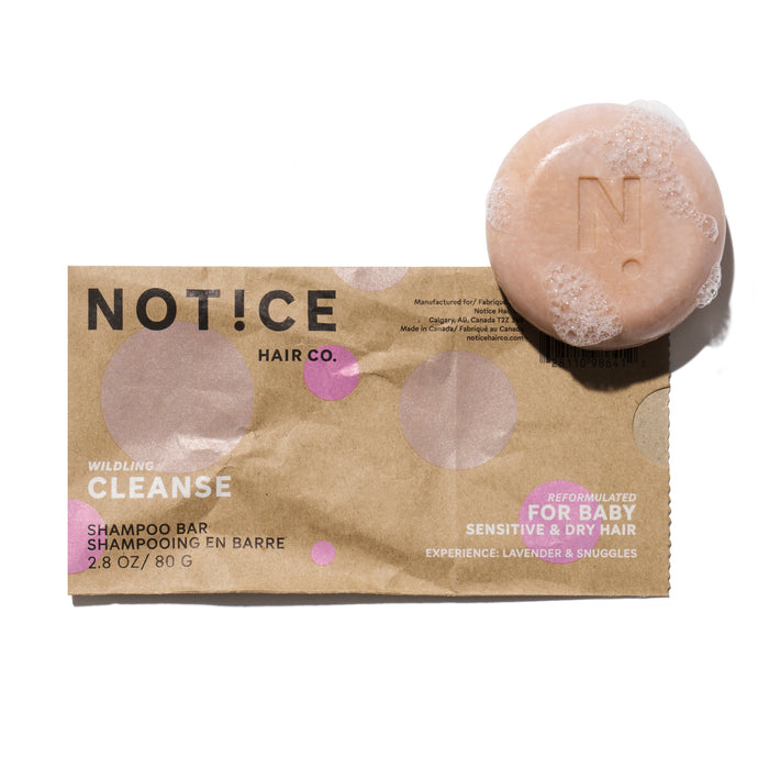 A pink NOTICE Hair Co. Baby Cleanse Shampoo Bar for sensitive, dry hair sits on its brown box—lavender & snuggles scent—perfect for plastic-free hair care.