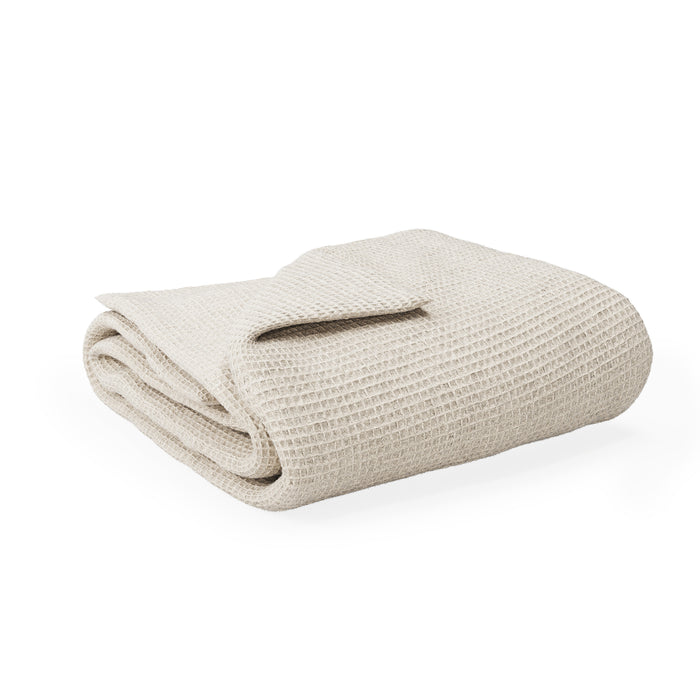 The Naturepedic Waffle Baby Blanket, made from GOTS-certified organic cotton in beige, is neatly folded and displayed against a white background.