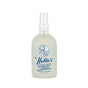 A clear spray bottle of Nellies Wrinkle-B-Gone - Lemongrass (3.38 fl oz) features a blue logo with a smiling woman and her dog, labeled as an antistatic fabric refresher—ideal for green cleaning on the go.