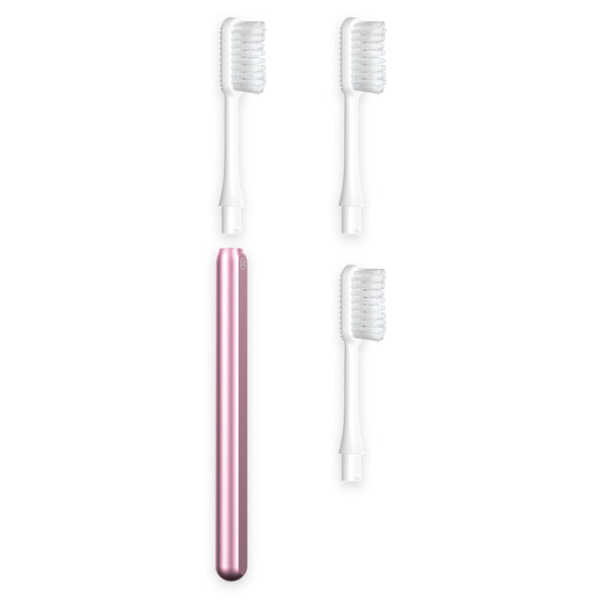 The Nada Medium Adult Toothbrush features a pink electric handle and three white replaceable brush heads with clear covers, designed to help reduce waste and extend your toothbrush’s life.