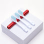 Three Nada Soft Kids Toothbrush heads with blue bristles are lined up on a red handle atop a white block, showing how switching heads helps reduce waste and encourages mindful recycling.