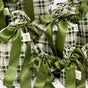 The Waste Free Celebrations Set of 10 Reusable Gift Bags - Tartan features green and white plaid fabric, each with a large green ribbon and label, gathered at the top for sustainable gift wrapping.