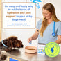 A veterinarian pours Native Pet’s Beef Bone Broth Topper for Dogs into a dog’s food bowl, citing its benefits for hydration and joint support. A brown dog eagerly waits by the bowl, excited for this nutritious topper.